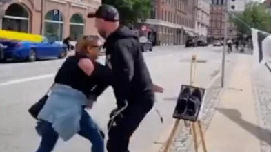 Danimarka polisi yanan Quranı götürmək istəyən qadına hücum etdi – VİDEO